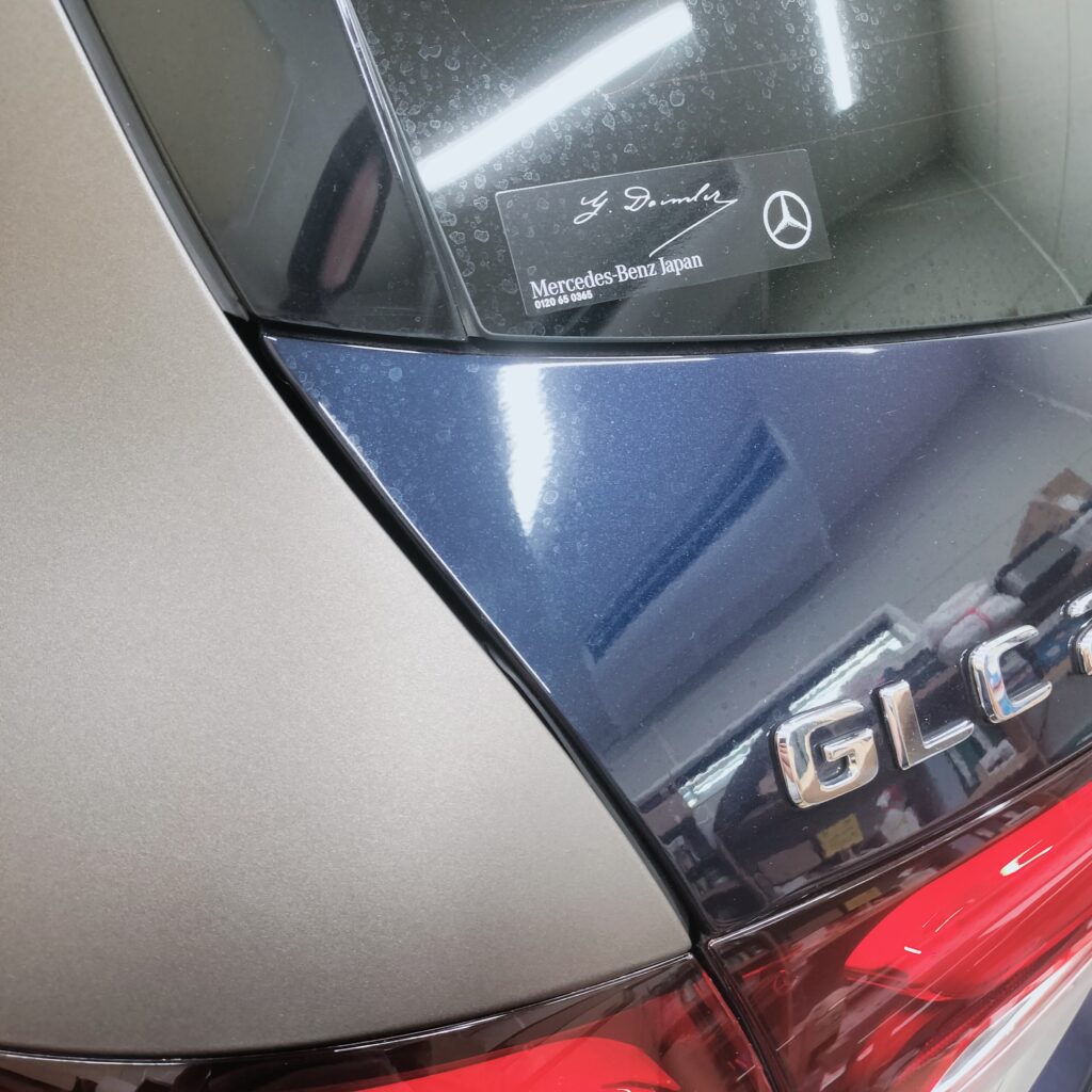 メルセデス・ベンツGLCのラッピング施工ディテール。元色のブルーとマットグレーフィルムの精密な境界線と、G. Daimlerのステッカー。